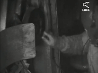 On-board radio operator who turns the crank to pick up the antenna wire. Taken from the film Luce.